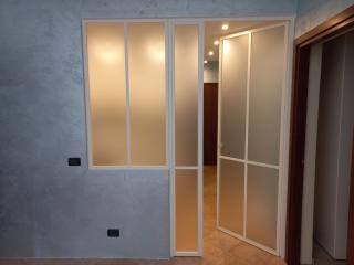 Porta con profili minimal in ferro che separa i due ambienti