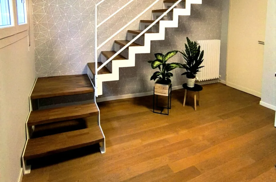 Scala con struttura in taglio laser portante in acciaio verniciato con gradini in faggio lamellare con tinta simile al parquet